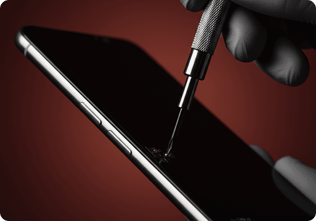 A technician repairing a phone with a screwdriver
