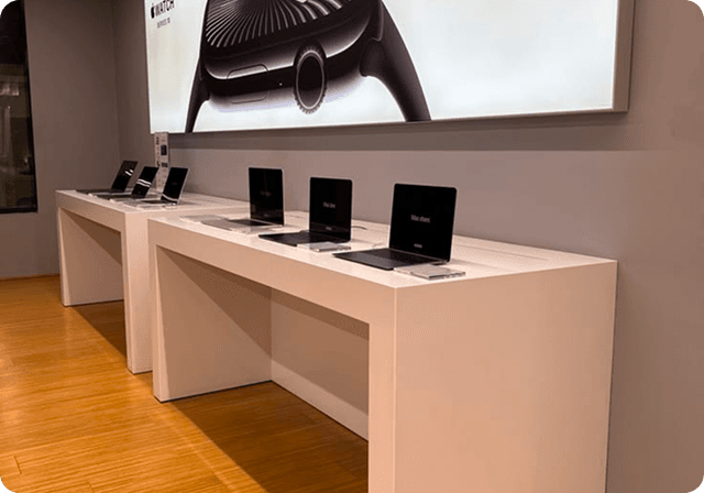 Laptops on display tables in a retail showroom